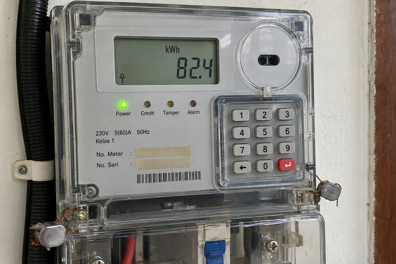 Layar meteran token setelah token dimasukkan menunjukkan sisa 82,4 kWh, dengan lampu Power menyala hijau. Foto dari sedikit menyamping supaya layarnya tidak silau.